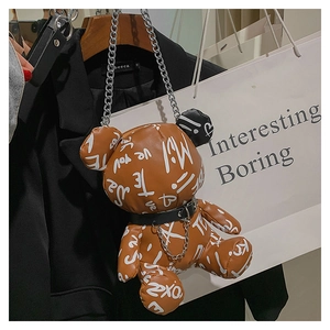Detailed macro view of the brown bear shaped bag with white graffiti and metal chain collar