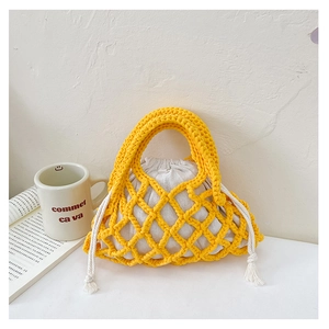 Detail of yellow woven hollow bucket bag with cotton drawstring liner and tassel