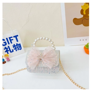 Detailed view of sequined girl handbag with pink mesh bow, crown charm and pearl handle
