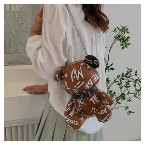 Detail of cute bear crossbody bag with white graffiti patterns and silver metal chain