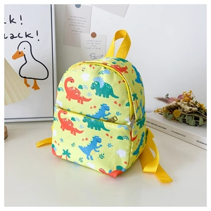 Detail of green kindergarten backpack with cartoon dinosaur pattern and canvas texture