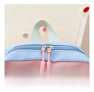 Detail view of pink and blue canvas backpack with double zippers and fashion logo