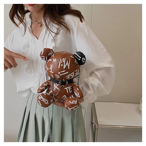 Close-up of brown graffiti teddy bear crossbody bag with silver chain strap for kids