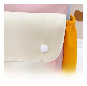 Detail of kids canvas backpack showing pink and cream panels with yellow side pocket