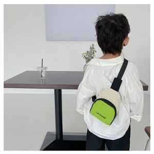 Vue arrière d'un enfant portant un sac à bandoulière en toile verte et crème