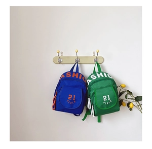 Detail of colorful mini canvas backpacks for kids with fashion text and front zip pocket