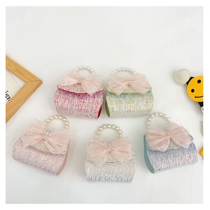 Macro shot of tweed mini handbags with pearl handles and oversized mesh bows in five colors