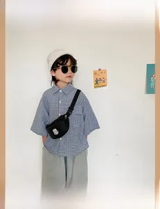 Close-up of a boy wearing a black canvas crossbody chest bag with adjustable strap