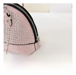 Detailed macro view of pink shell bag featuring silver rhinestones and chain strap