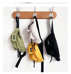 Dettaglio dei marsupi in nylon per bambini nei colori oliva, beige, giallo e nero