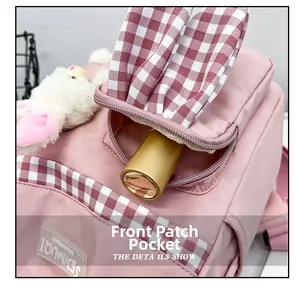 Detailed front pocket of pink bunny backpack showing checkered trim and fabric brand tag