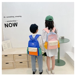 Detail view of stylish color-block kids backpacks with adjustable shoulder straps and top handle