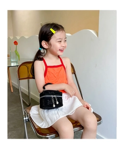 Détail d'un mini sac enfant noir brillant avec fermeture éclair ornée de perles