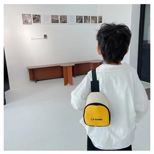 Détail du sac de poitrine en toile jaune et blanc pour enfant avec bandoulière réglable