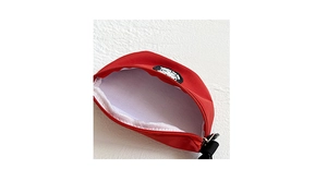 Detail view of red canvas chest bag with white lining and circular logo patch detail