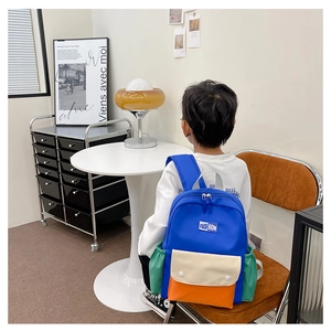 Detailed view of color-block kids backpack with waterproof nylon and side pockets