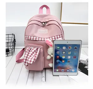 Pink rabbit ear backpack side view with iPad for size comparison and plush pendant