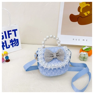 Detail of light blue kids handbag with floral jacquard texture and pearl handle