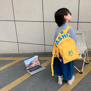 Toddler yellow canvas backpack with fashion print shown on child in outdoor setting