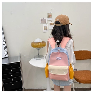 Detailed back view of a kids' colorful contrast backpack worn by a child in a home setting