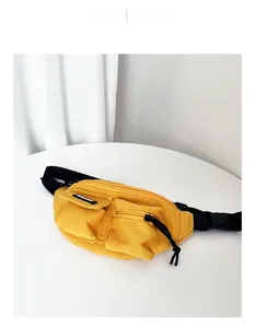 Dettaglio del marsupio giallo da bambino in tela con design multitasca e cinturino