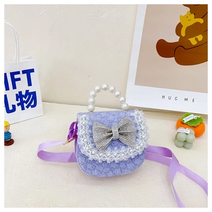 Detail of purple lace girls handbag with rhinestone bow and pearl handle in gift setting