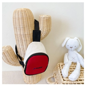 Détail du sac de poitrine en toile rouge et blanc pour enfant sur support cactus