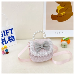 Detail of pink lace children handbag with pearl handle and rhinestone bow decoration