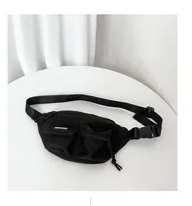 Dettaglio del marsupio in nylon nero resistente con tasche multiple e fibbia