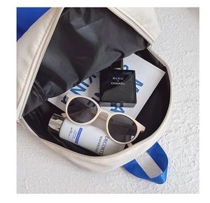 Vue intérieure du sac à dos en toile blanche montrant le rangement des accessoires