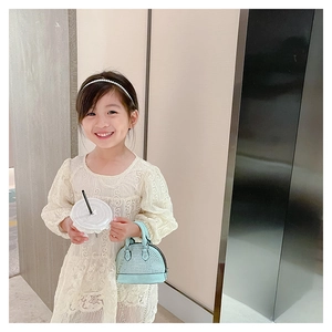 Detail of light blue shell-shaped toddler crossbody bag with rhinestones and metal chain