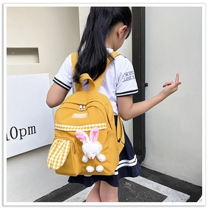 Detail of yellow toddler backpack with plush bunny and yellow-white checkered texture