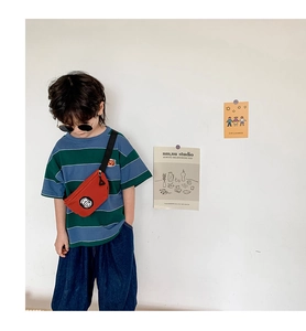 Detail of red crossbody chest bag paired with a blue and green striped t-shirt for boys