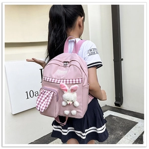 Detailed view of pink girls backpack with cute plush rabbit charm and checkered details