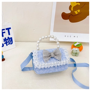 Detail of light blue lace kids handbag featuring rhinestone bow and pearl handle