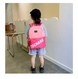 Détail du sac à dos en toile rose bicolore sur le dos montrant le logo TOCHASO