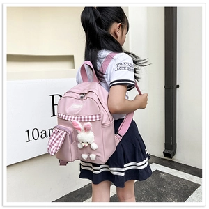 Pink child backpack with cute bunny plush and checkered detail worn by a little girl