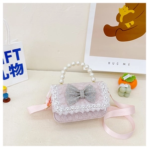 Detail of pink lace girls' bag with rhinestone bow, pearl handle and adjustable strap
