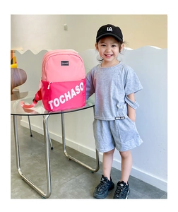 Détail d'un sac à dos enfant bicolore rose avec fermeture éclair et logo