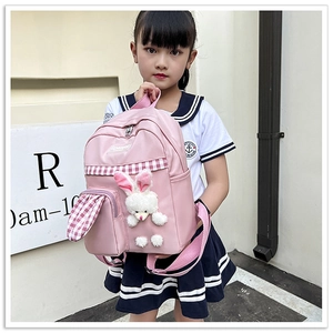 Pink child backpack with plush bunny ears and checkered pattern on girl model