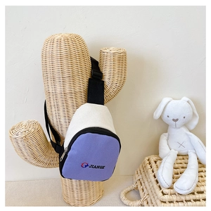Détail d'un sac de poitrine enfant en toile violet et blanc avec sangle réglable et logo