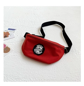Detail view of red nylon waist bag with Fashion circular label and adjustable black strap