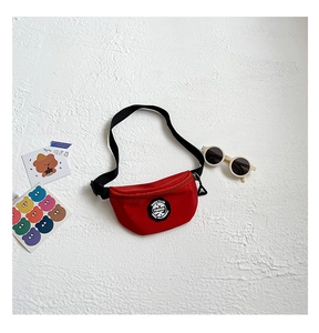 Close-up of a red kids fanny pack with fashion print and adjustable strap on white texture