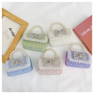 Detailed view of kids mini pearl handbags with bow accents in five pastel colors