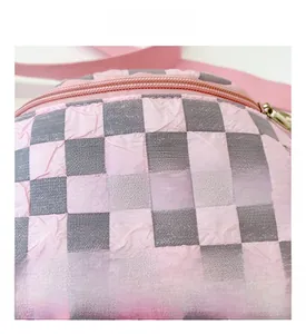 Detailaufnahme des rosa-grau karierten Faltenstoffs mit Fashion-Label-Patch
