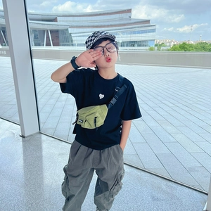 Set streetwear per bambini con t-shirt nera, pantaloni cargo grigi e borsa verde