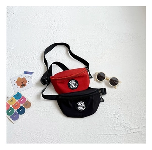 Close-up of children's fashion crossbody chest bags in red and black with adjustable straps