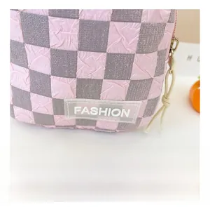 Nahaufnahme der rosa karierten Tasche mit Bubble-Textur, FASHION-Label und gewebtem Reißverschluss