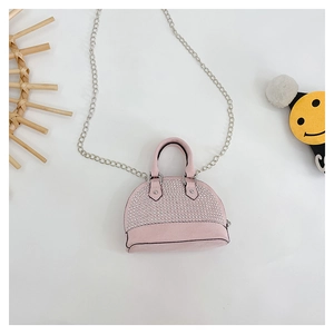 Detail view of pink mini shell bag featuring sparkling rhinestones and silver chain strap