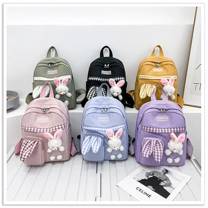 Close-up of cute backpacks in six colors with rabbit ears and plush pendants